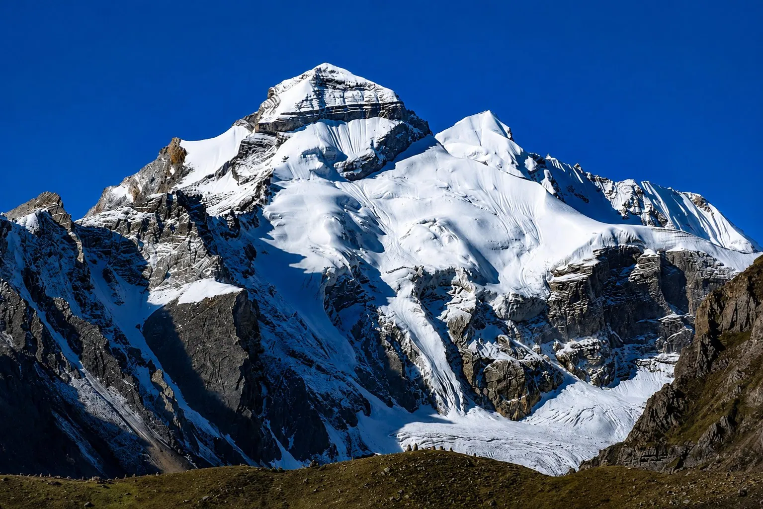 Adi Kailash from Jolingkong: a snow-covered pyramid of rock above a glacier, against a deep blue sky
