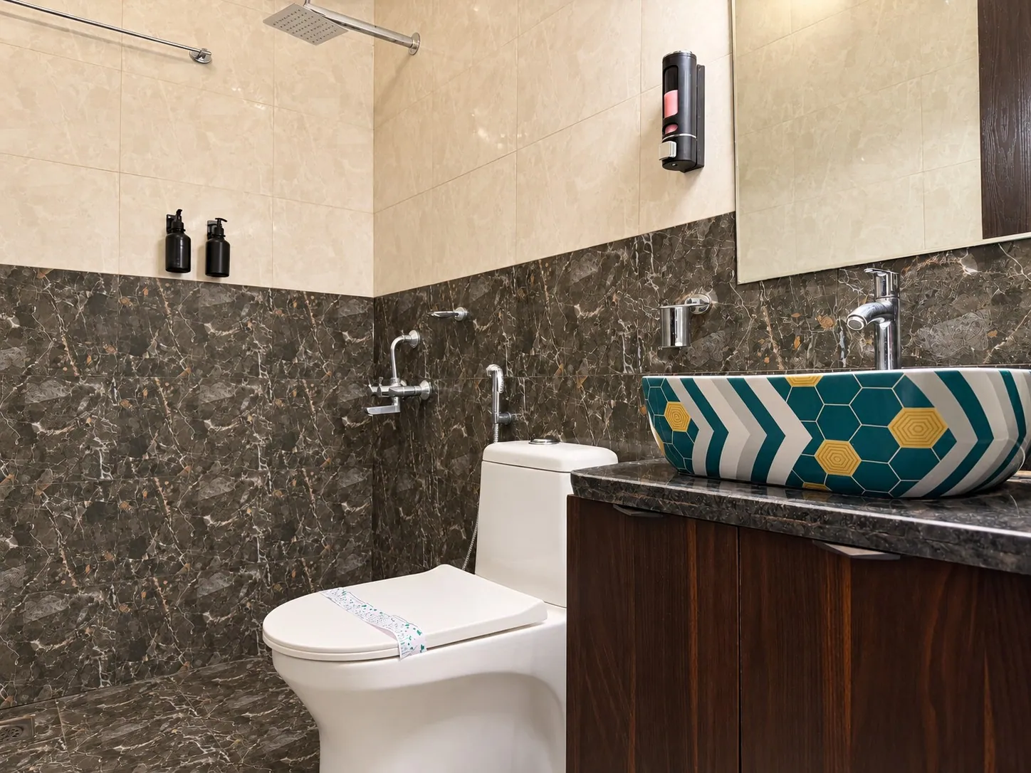The bathroom with a rain shower, a patterned basin and a walnut vanity