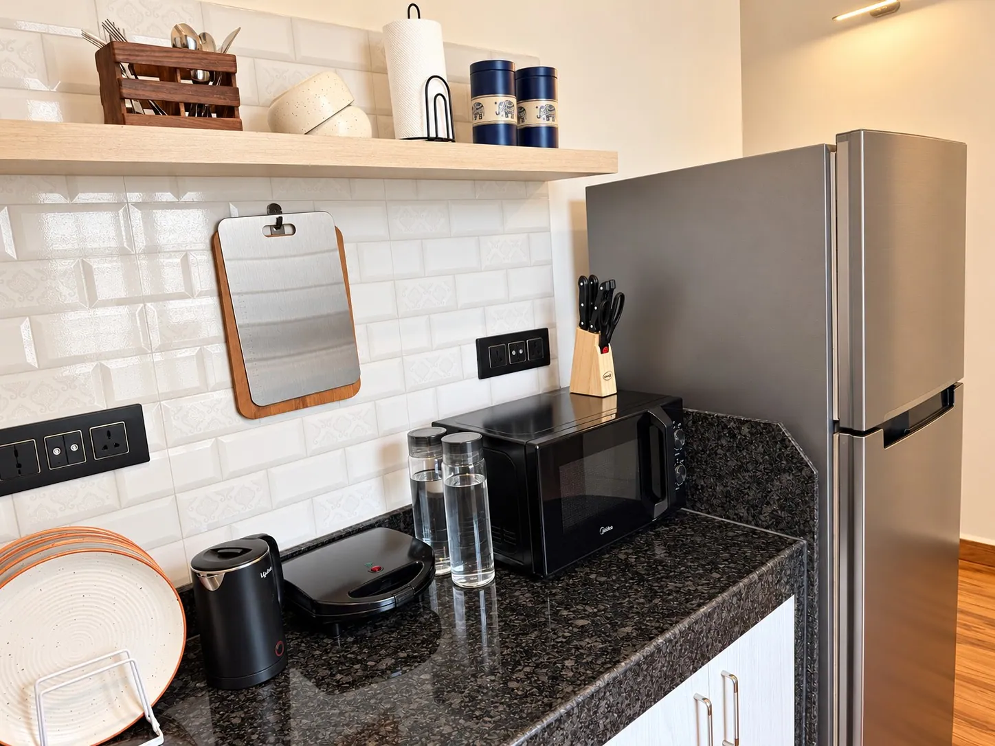 The kitchenette: fridge, microwave, induction cooktop, kettle and open shelves