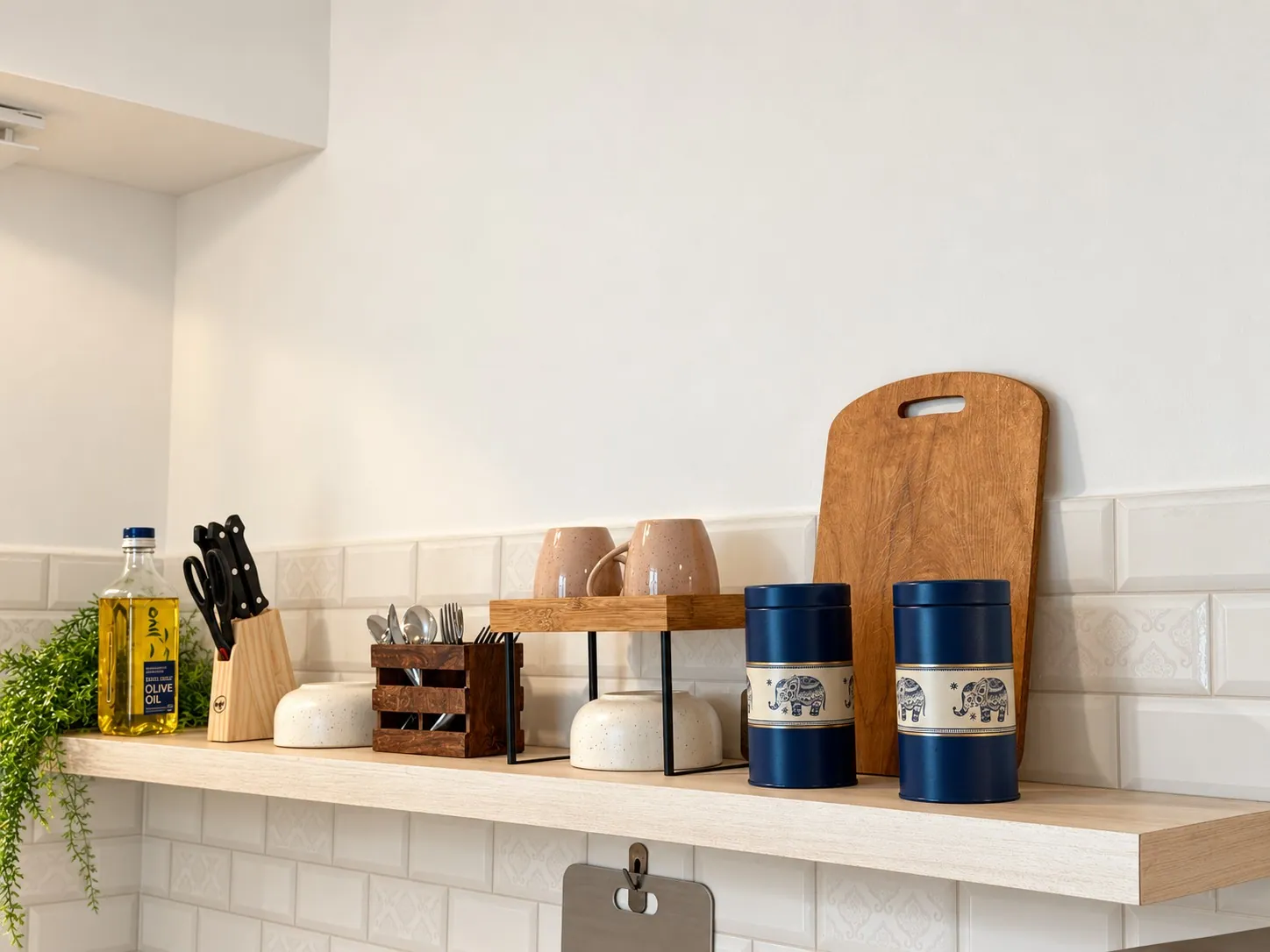 The kitchen shelf with oil, knives, cutlery and storage jars