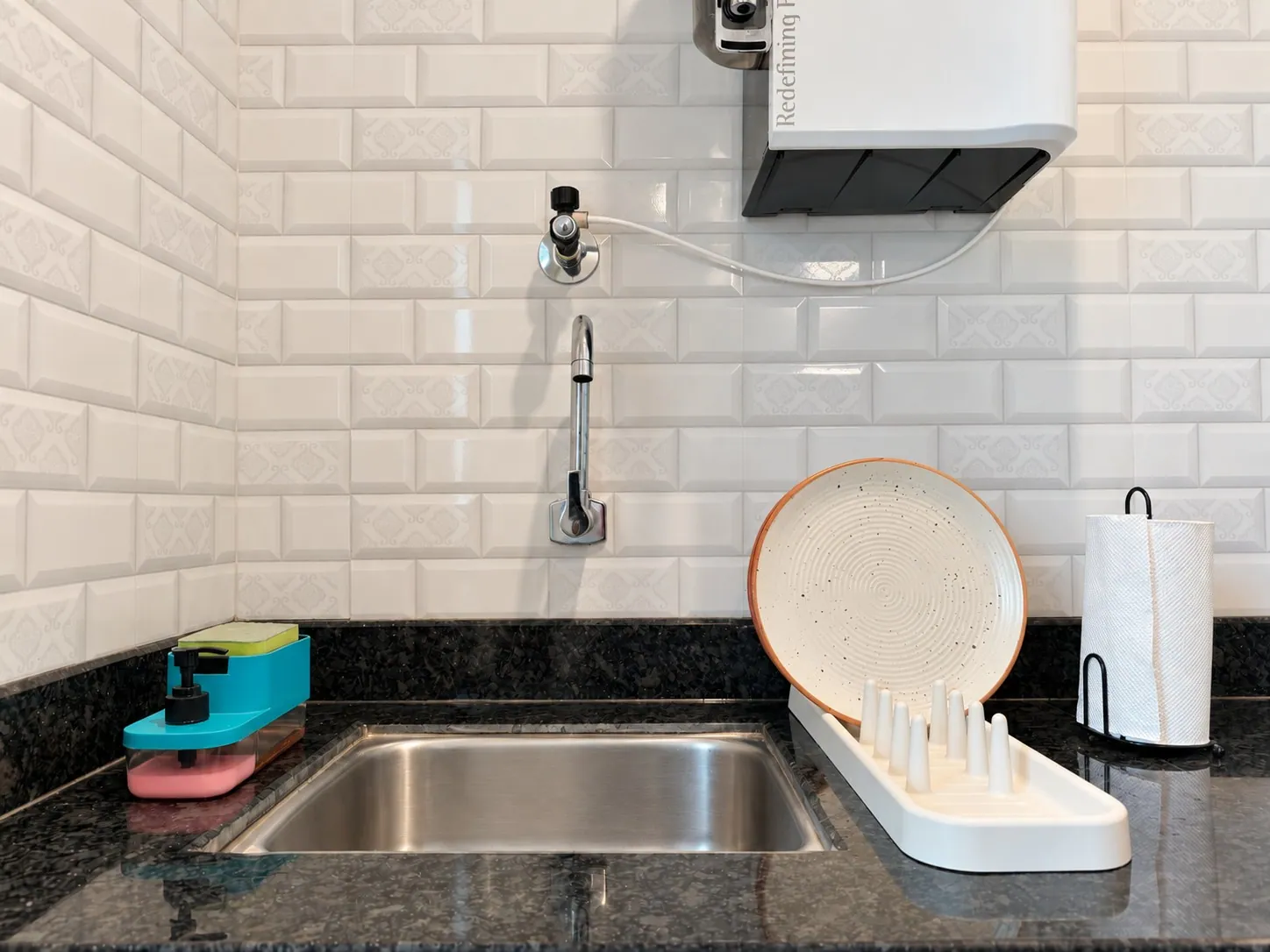 The steel sink with a dish rack and washing-up supplies
